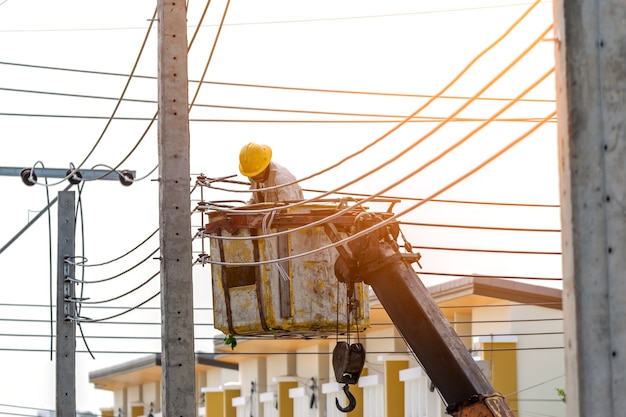 O eletricista foi até a cesta do guindaste para instalar o cabo de força.