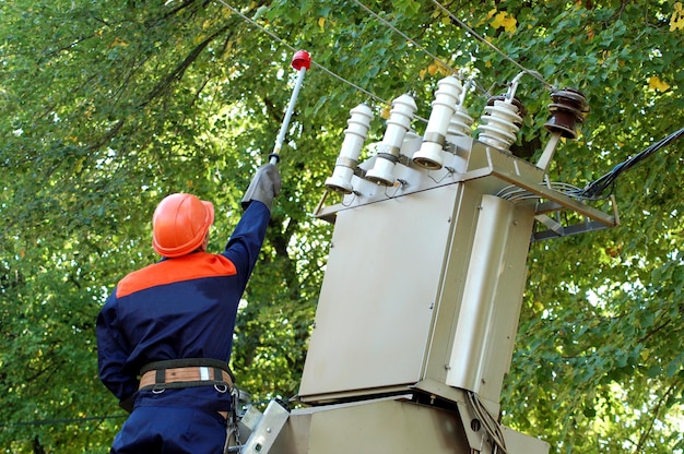 O eletricista instala a terra na linha de energia antes de reparar a subestação