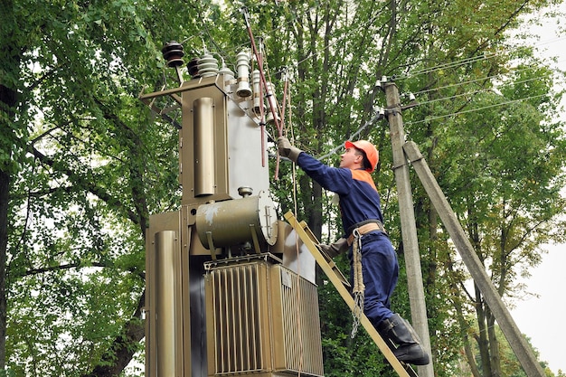 O eletricista instala o aterramento na linha de energia antes do representante