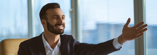 Foto o empresário feliz com um laptop sentado na mesa