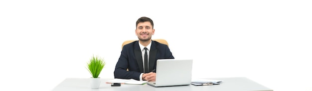 O empresário feliz sentado na mesa no fundo branco