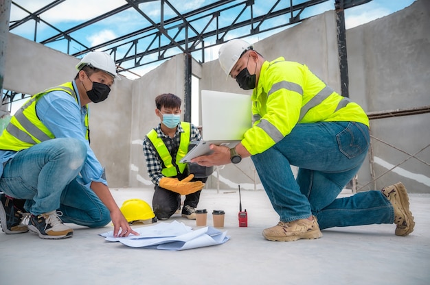 O engenheiro civil inspeciona a estrutura no canteiro de obras em relação ao projeto, os inspetores de construção inspecionam em conjunto a estrutura do edifício com o engenheiro civil. Engenheiro civil segura planta inspecionar edifício.