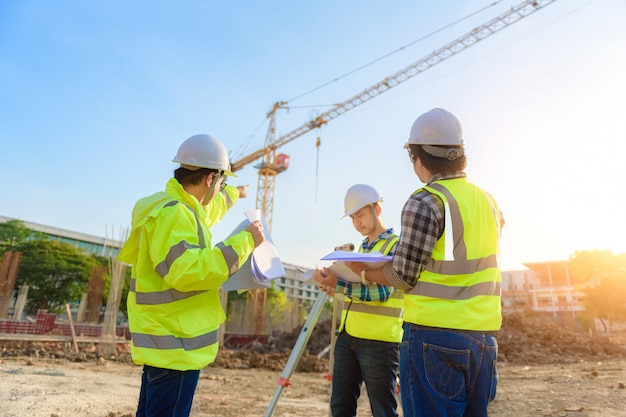 O engenheiro civil inspeciona o trabalho usando comunicação via rádio com a equipe de gerenciamento na área de construção.