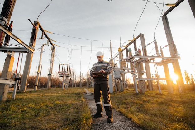 O engenheiro de energia inspeciona os equipamentos da subestação. engenharia de energia. indústria