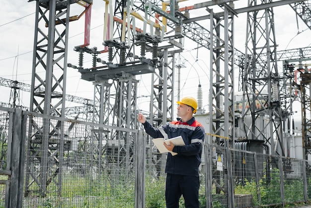 O engenheiro de energia inspeciona os equipamentos da subestação. Engenharia de Energia. Indústria.