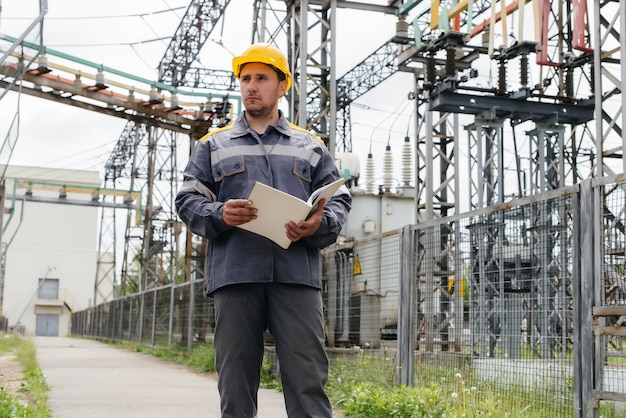 O engenheiro de energia inspeciona os equipamentos da subestação