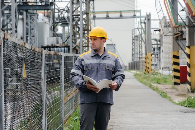 O engenheiro de energia inspeciona os equipamentos da subestação.