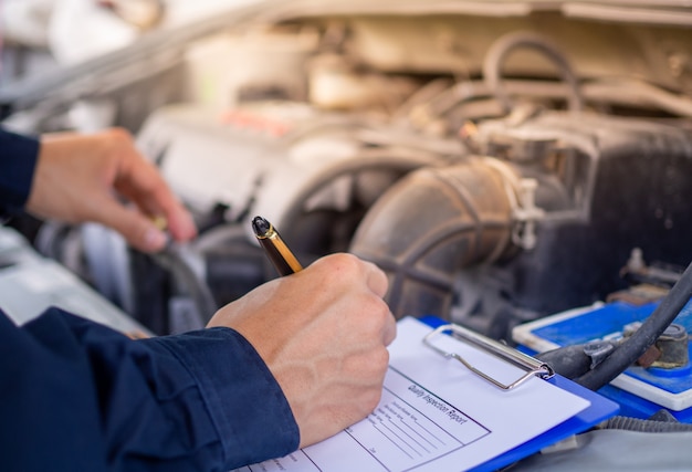 O engenheiro do motor está verificando e reparando o carro. Serviços de atendimento externo