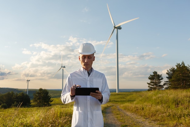 O engenheiro verifica o sistema da turbina eólica com um tablet.