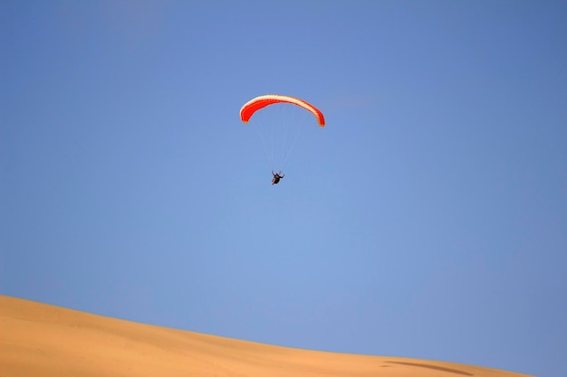 O esporte de pular de uma duna de areia e realizar manobras acrobáticas no ar durante a queda livre antes do pouso de paraquedas