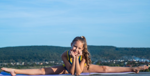 O esporte é a nossa vida adolescente feliz em criança dividida tem criança de corpo flexível em roupas esportivas conceito de treinamento de alongamento e aquecimento infância felicidade saúde e fitness ginástica