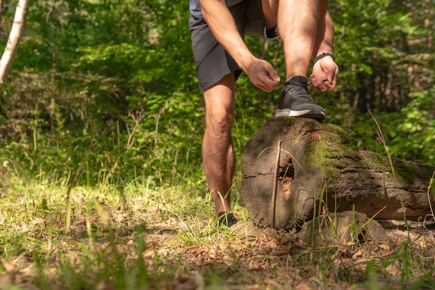 O esportista está amarrando os cadarços de suas pernas em tênis fecham o atleta corre no parque