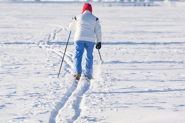 O esquiador entra na pista em um dia ensolarado de inverno.