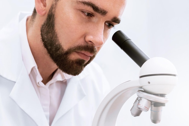 O estudante está usando o microscópio em um laboratório durante o trabalho de pesquisa científica