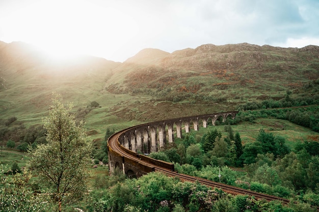 Foto o famoso viaduto de glenfinnan, nas pitorescas terras altas da escócia, em um dia ensolarado
