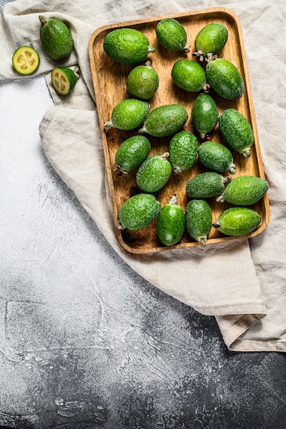 O feijoa verde frutifica em uma placa de madeira em um fundo cinzento. Feijoa de frutas tropicais. Vista do topo