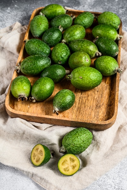 O feijoa verde frutifica em uma placa de madeira em um fundo cinzento. Feijoa de frutas tropicais. Vista do topo