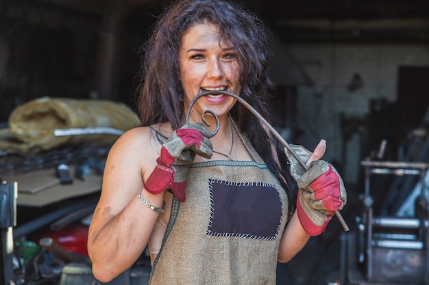 Foto o ferreiro da menina bonita morde uma haste de metal curvada