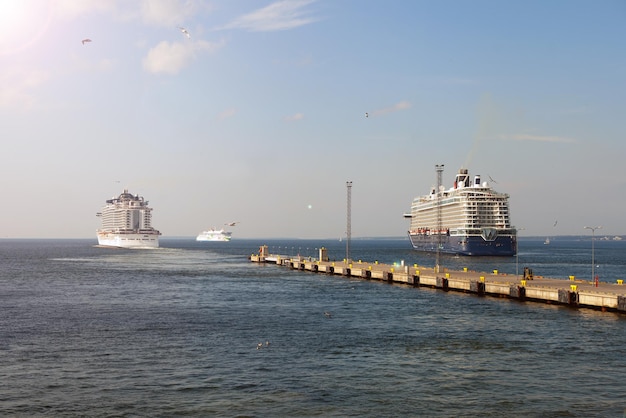 O forro do navio de cruzeiro entra no horizonte do mar azul deixando o conceito de paisagem marítima da água do porto de viagens marítimas