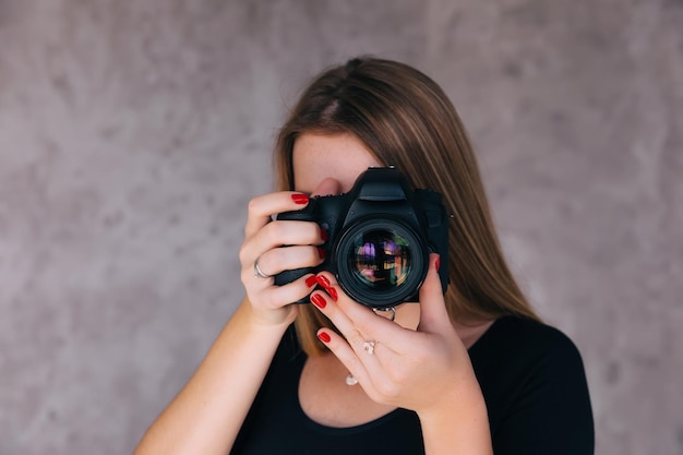 O fotógrafo da mulher está tirando imagens com o estudante da câmera dslr le