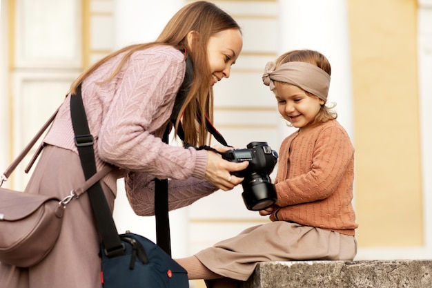 o fotógrafo mostra as fotos tiradas para a criança na câmera durante uma sessão de fotos