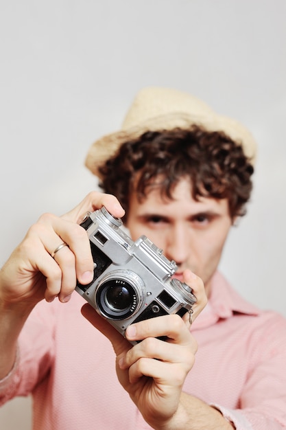 O fotógrafo olha para o visor da câmera.