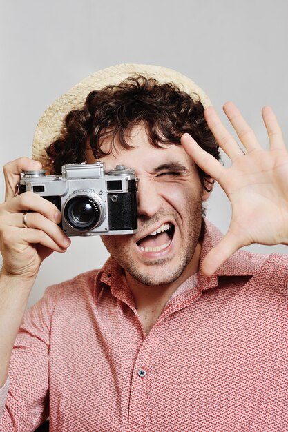 O fotógrafo olha para o visor da câmera.