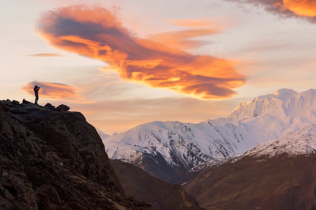 O fotógrafo tira fotos na montanha. Silhueta do fotógrafo no topo da montanha