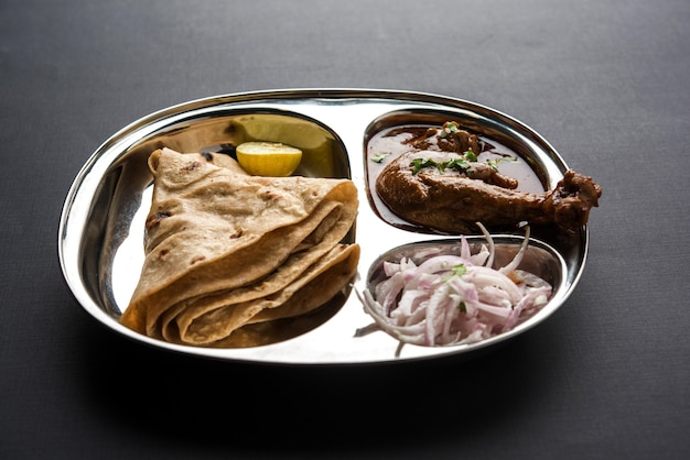 O frango kolhapuri thali é um prato popular de comida indiana e asiática que consiste em carne de frango, curry de ovo com chapati, arroz, salada e doce gulab jamun