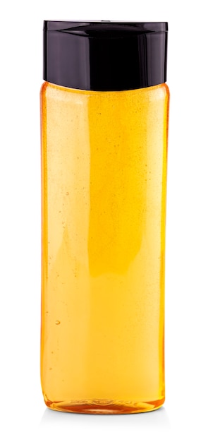 O frasco de shampoo amarelo em um fundo branco