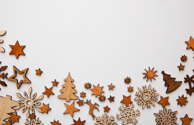 O fundo bonito do natal com muitas pequenas decorações de madeira em cima da mesa branca.