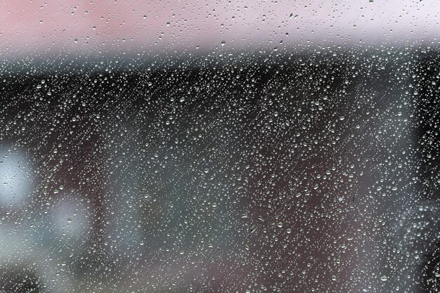 Foto o fundo das gotas de chuva na janela chove lá fora