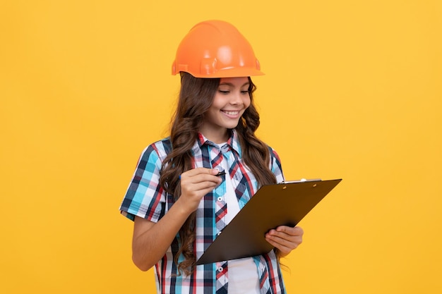 O futuro engenheiro segura a experiência de trabalho de segurança da área de transferência adolescente com capacete de proteção