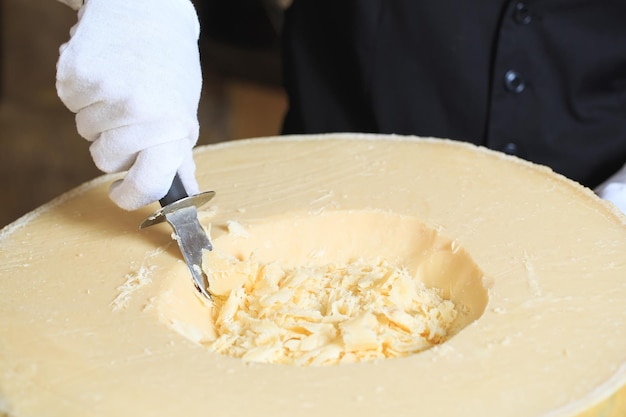 Foto o garçom corta pedaços de queijo parmesão