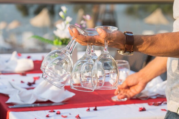 O garçom segura taças de vinho na mão