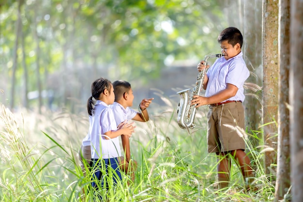 O garoto está tocando saxofone Divirta-se ouvindo amigos.