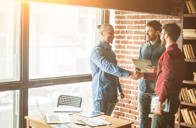 O gerente da empresa dá as boas-vindas ao cliente com um aperto de mão