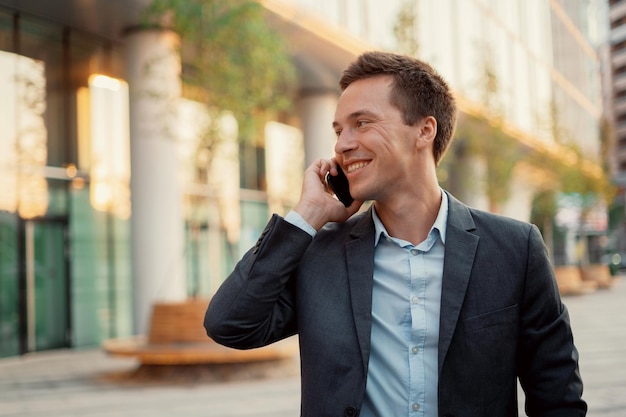 Foto o gerente está segurando um telefone nas mãos retrato de um jovem investidor empreendedor