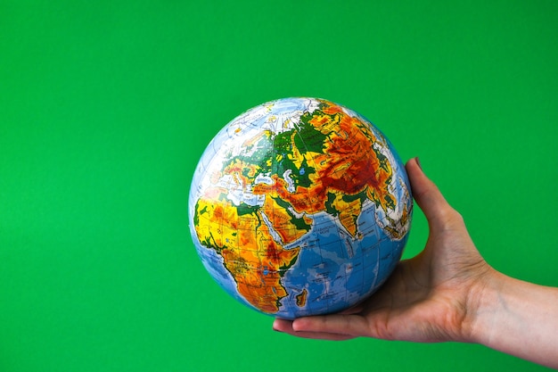 O globo nas mãos das crianças no conceito de globalização de fundo colorido