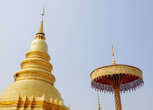 O grande pagode dourado e o guarda-chuva dourado no estilo tradicional do norte da Tailândia