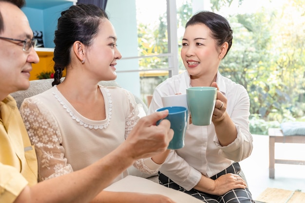 O grupo de asiático sênior aposentou-se a reunião do amigo e a beber o café no lar de idosos.