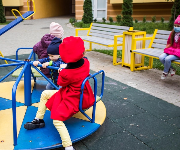 O grupo de crianças com máscaras médicas em um playground da cidade