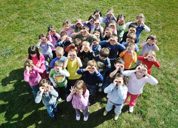 o grupo de crianças felizes se diverte e brinca no conceito de educação pré-escolar ao ar livre do jardim de infância com o professor