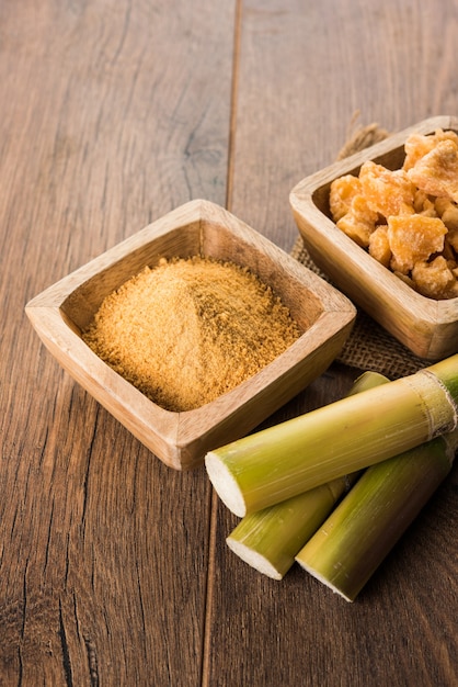 Foto o gur orgânico ou jaggery em pó é o açúcar não refinado obtido do caldo concentrado da cana-de-açúcar. servido em uma tigela. foco seletivo