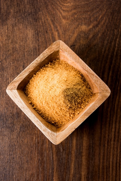 O gur orgânico ou jaggery em pó é o açúcar não refinado obtido do caldo concentrado da cana-de-açúcar. servido em uma tigela. foco seletivo