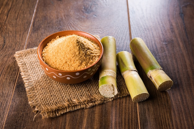 O Gur orgânico ou Jaggery em pó é o açúcar não refinado obtido do caldo concentrado da cana-de-açúcar. servido em uma tigela. foco seletivo