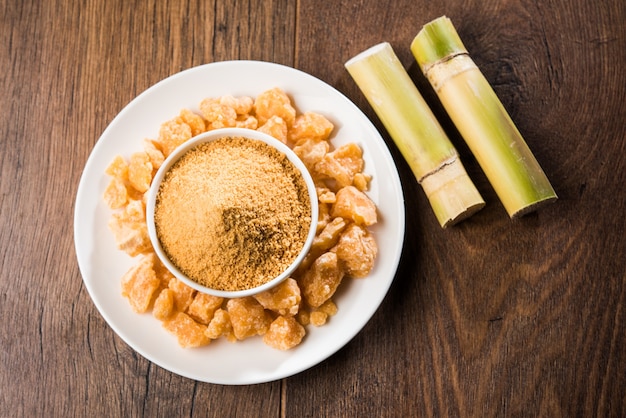 O gur orgânico ou jaggery em pó é o açúcar não refinado obtido do caldo concentrado da cana-de-açúcar. servido em uma tigela. foco seletivo