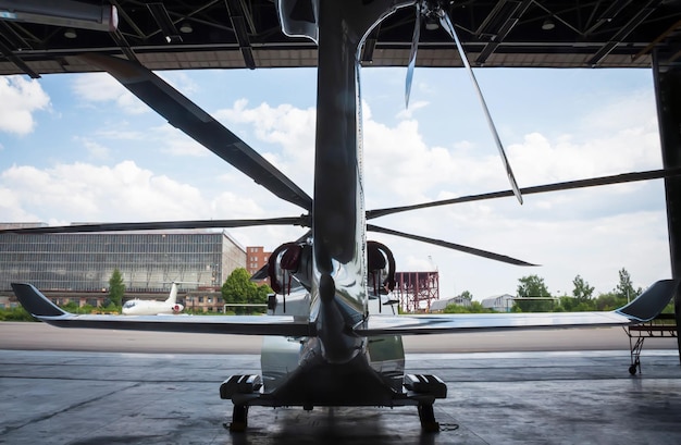 Foto o helicóptero está no hangar. vista traseira