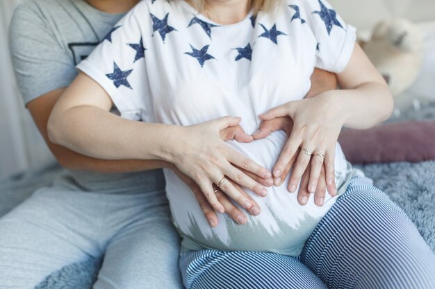 o homem acaricia a barriga da esposa grávida