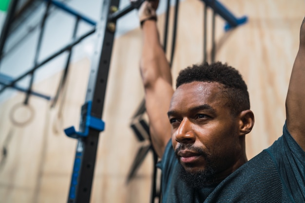 O homem atlético que faz levanta o exercício na ginástica.